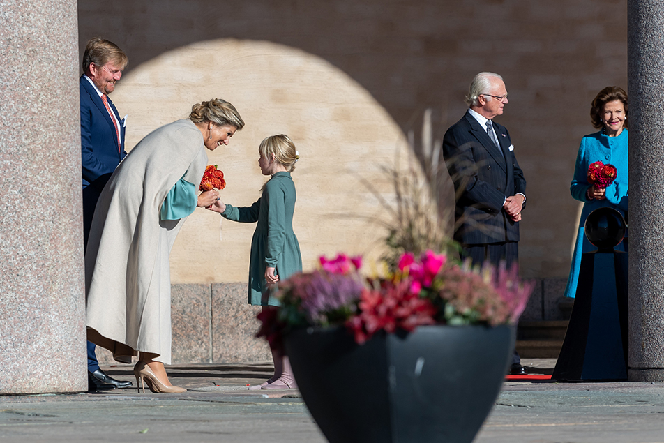 Drottningarna välkomnades av blomsterflickor vid ankomsten till Stadshuset.