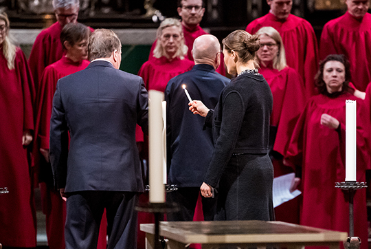 Kronprinsessan och statsministern tänder ljus vid minnesstunden i Storkyrkan. 