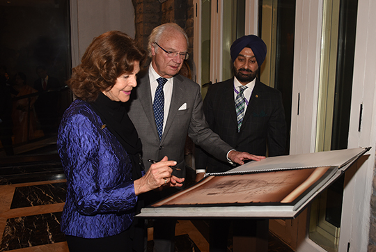 Kungaparet tillsammans med hotellchefen Tajinder Singh vid signeringen av minnesmonumentets gästbok. 