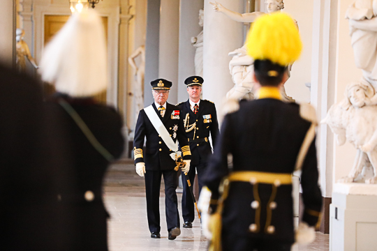 Kungen anländer till dagens ceremoni och hälsar på vaktchefen och slottsväbeln i Kungliga slottets östra valv. 