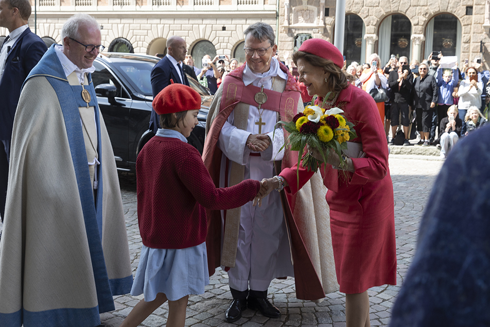 Drottningen tar emot en blomsterbukett av Ronja Isla Nilsson vid ankomsten.