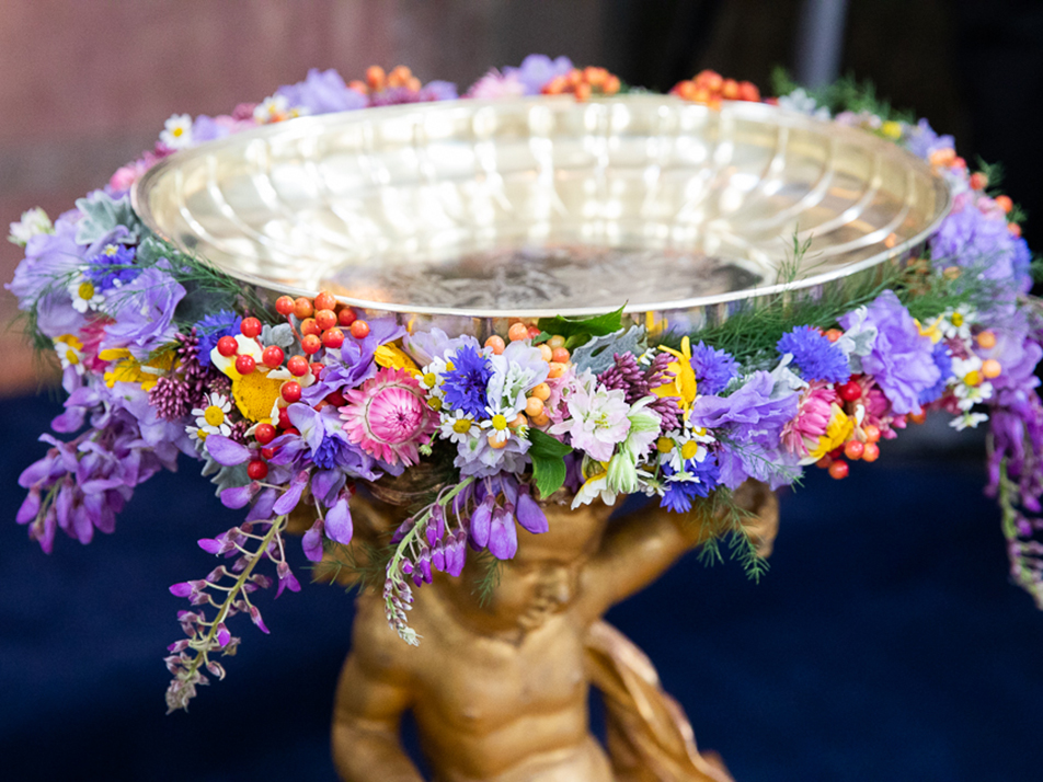 The baptismal font in the Palace Chapel, decorated with flowers.