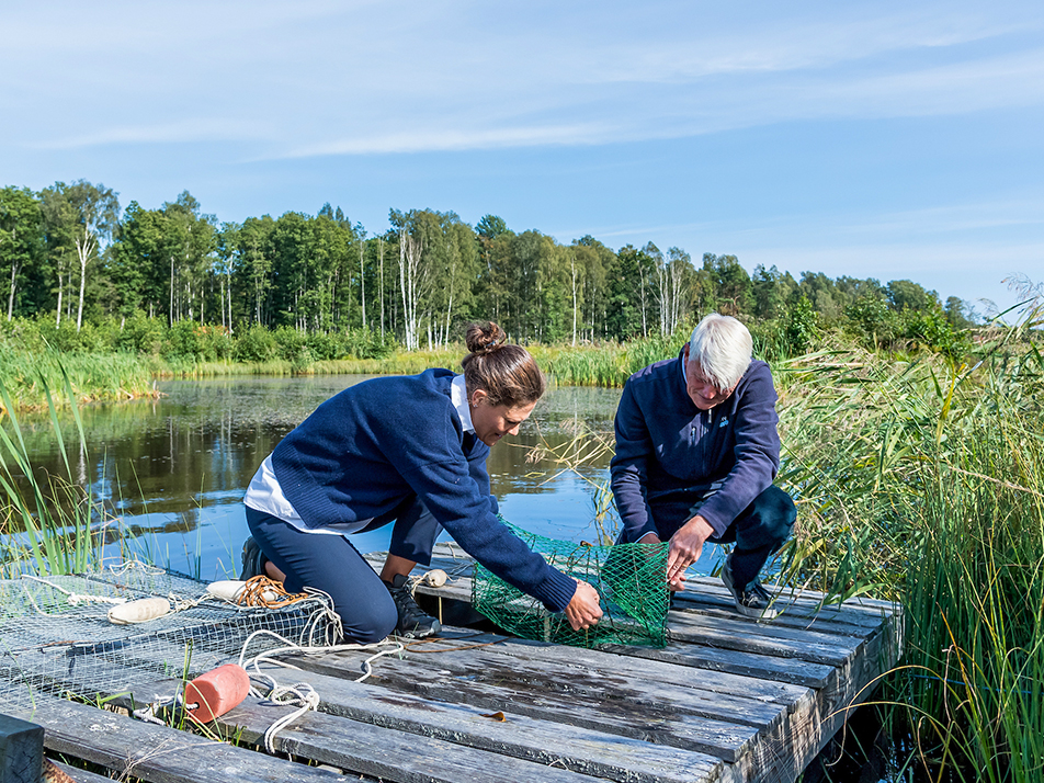 Kronprinsessan tillsammans med Thomas Hjelm som berättar om hur flodkräftan är en viktig del av ekosystemet för våtmarken på Utö. 