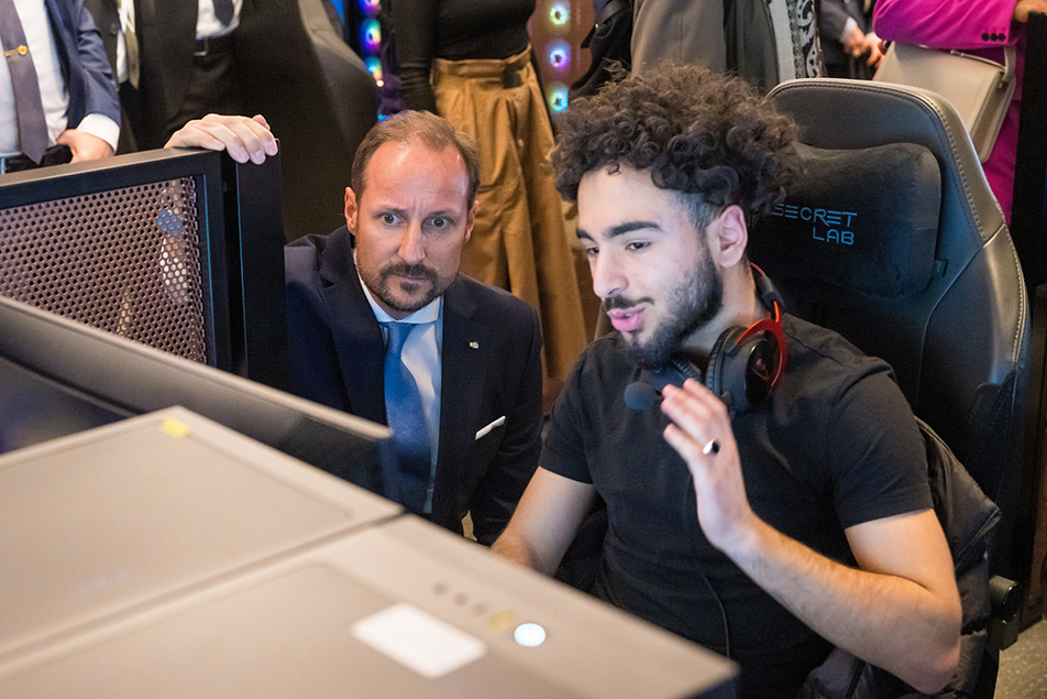 Crown Prince Haakon speaks with one of the young people studying coding. 