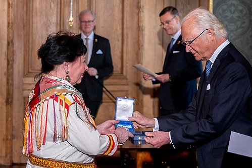 Åsa Simma tar emot sin medalj ur Kungens hand för betydande insatser inom samisk scenkonst. 