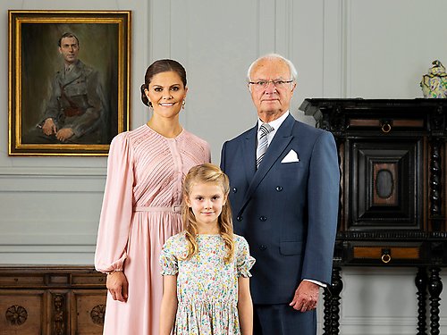 H.M. Konungen, Sveriges statschef, tillsammans med H.K.H. Kronprinsessan och H.K.H. Prinsessan Estelle. Kronprinsessan och Prinsessan Estelle är tronarvingar och första och andra personer i tronföljden. Porträttet i bakgrunden föreställer Kungens framlidne far, arvprins Gustaf Adolf. 