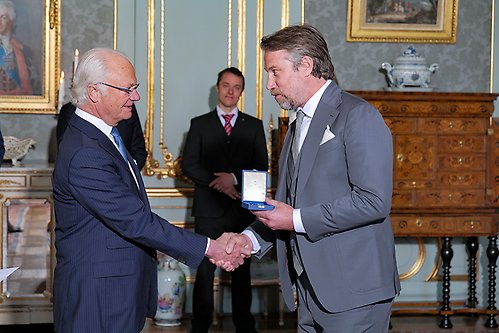 Ishockeyspelare Peter Forsberg tar emot sin medalj ur Kungens hand.