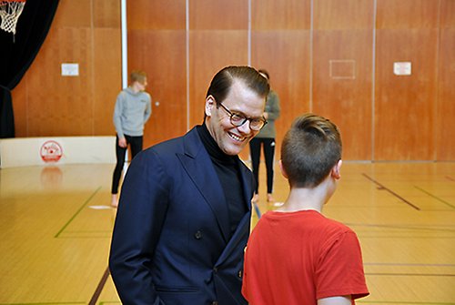 Prins Daniel i samtal med en elev i gymnastiksalen i Juvanpuisto skola i Esbo.
